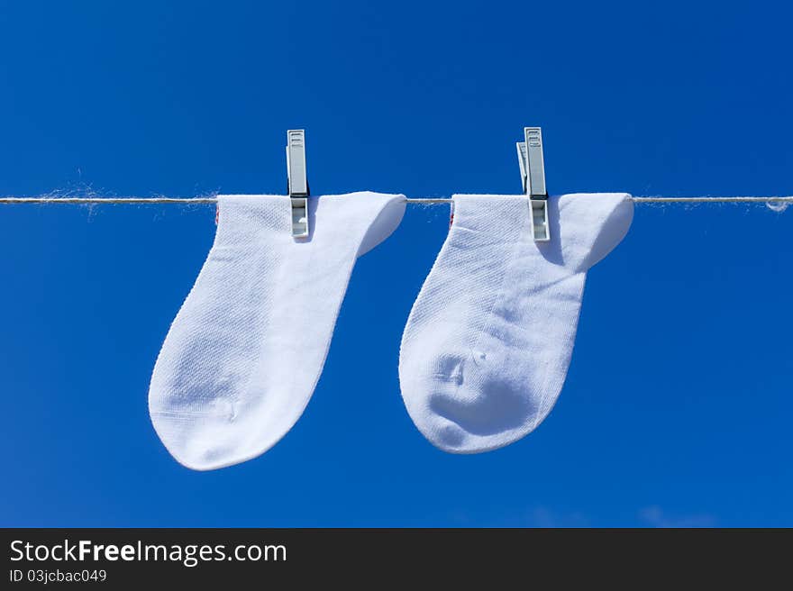 Socks hanging to dry over blue background