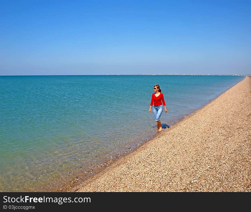 Young Woman Walking On A Coastline