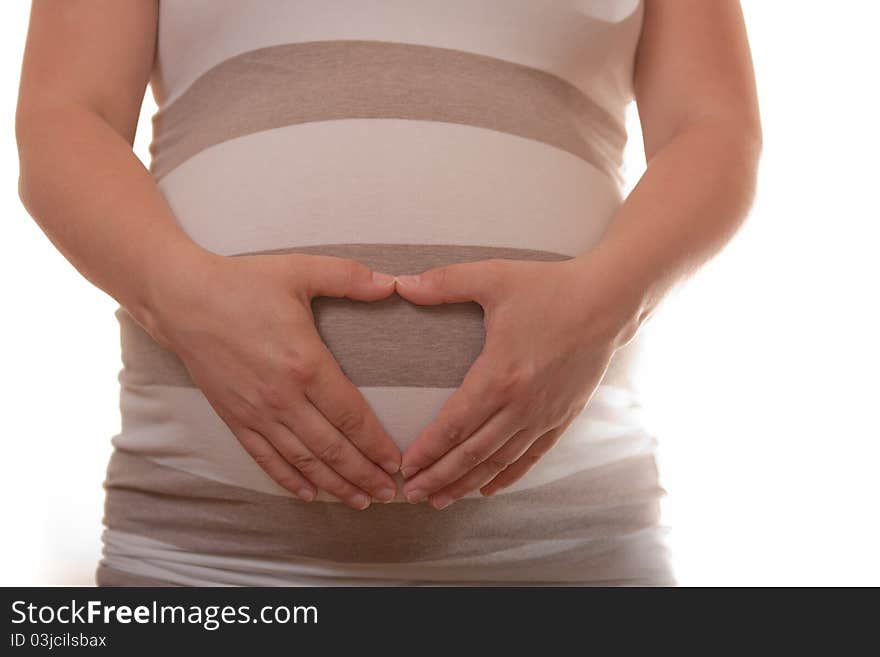 Woman's belly in 9th month of pregnancy on a white background. Hands form hart on the belly. Woman's belly in 9th month of pregnancy on a white background. Hands form hart on the belly