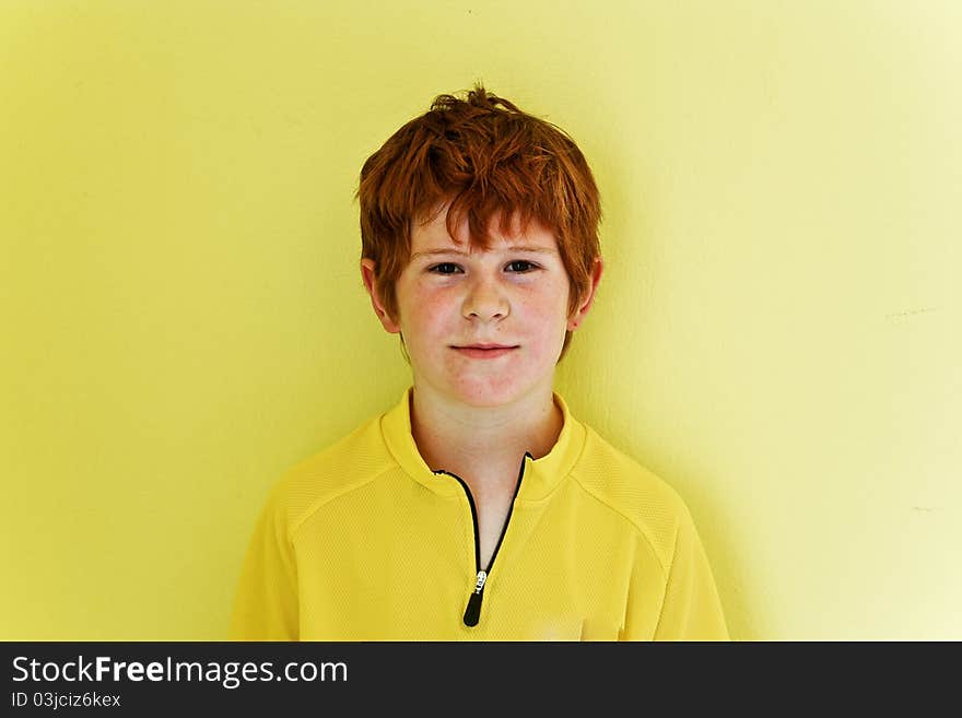 Portrait of friendly looking boy with yellow background