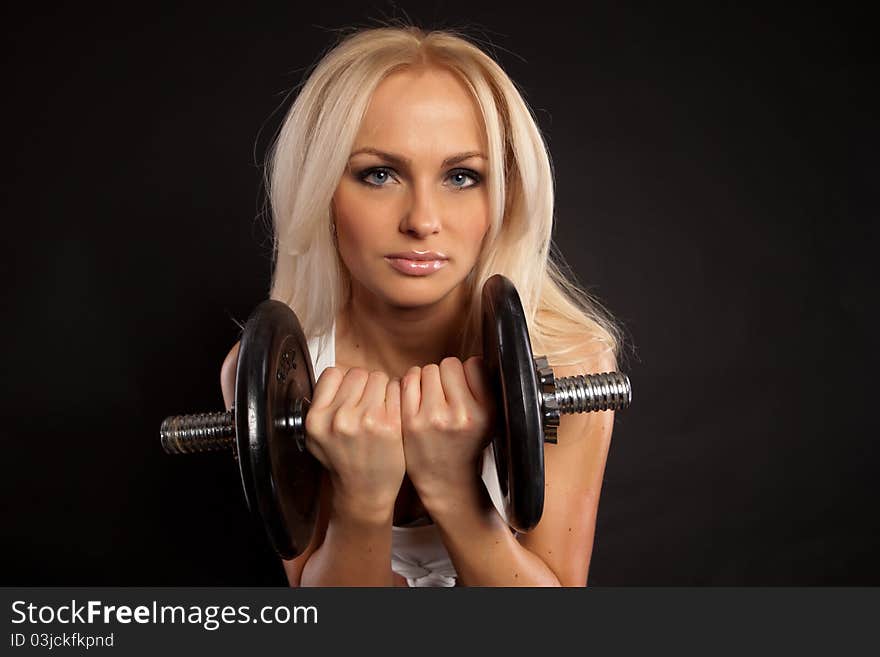 Strong young girl working out with dumbbells.