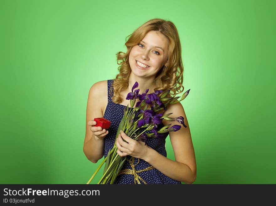 Close-up Happy young woman in one hand holding a bouquet of irises and other red gift box. Marriage proposal. Close-up Happy young woman in one hand holding a bouquet of irises and other red gift box. Marriage proposal