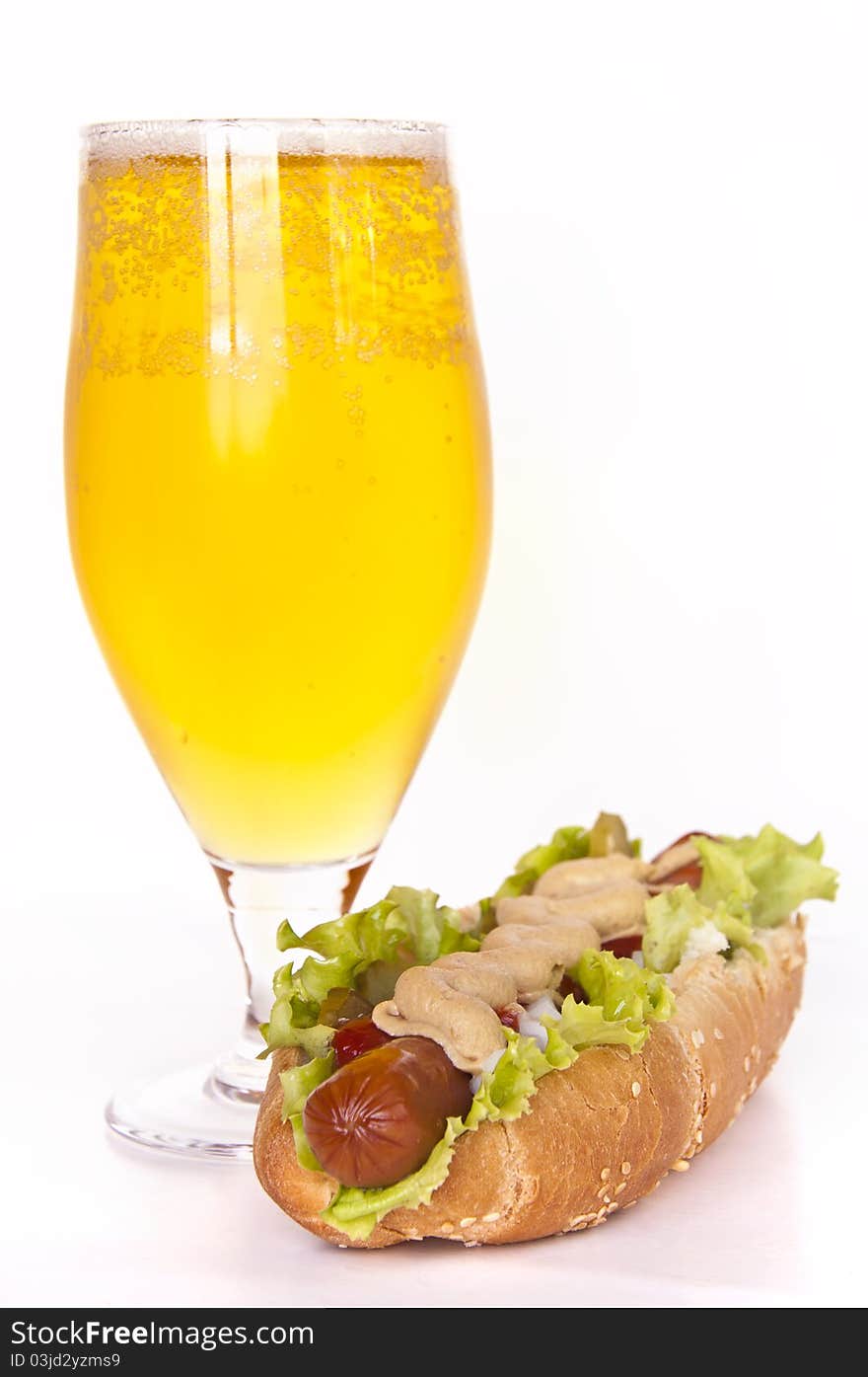 Glass of beer and hot dog on the white background. Glass of beer and hot dog on the white background