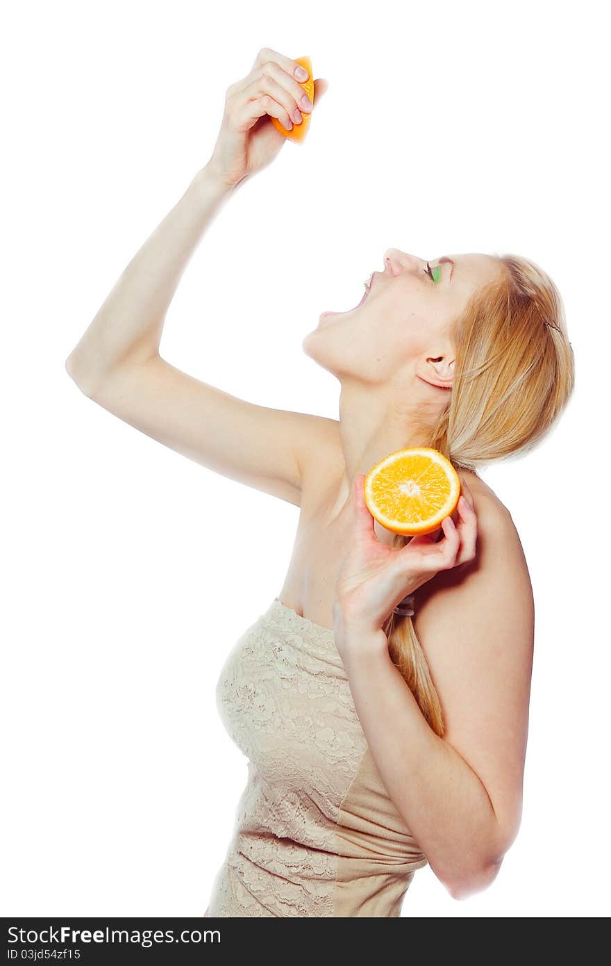 Woman drinking juice direct from an orange fruit