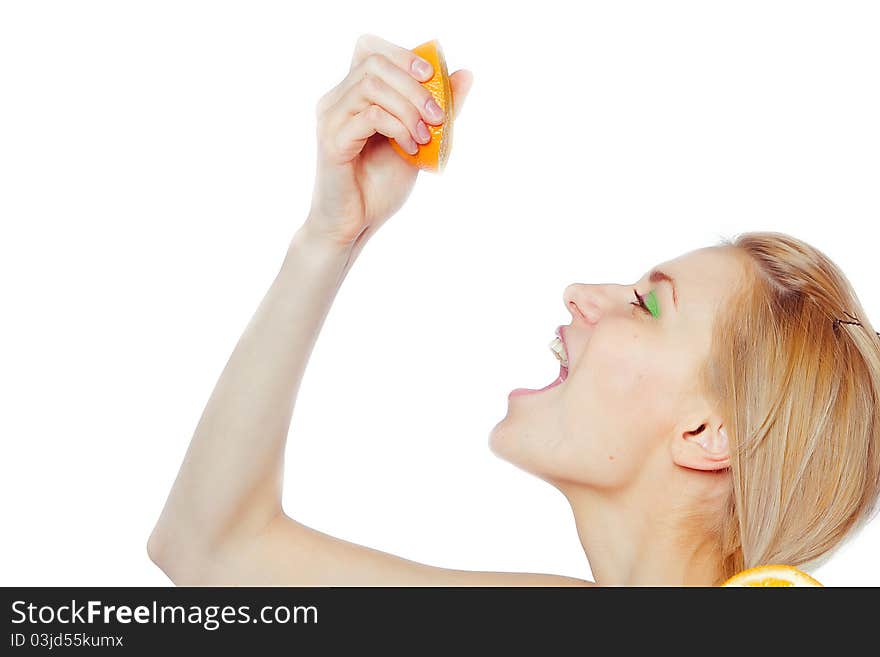 Woman drinking juice direct from an orange fruit