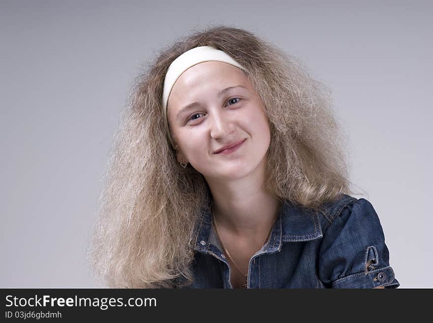 Portrait of a young beautiful woman on a gray background closeup. Portrait of a young beautiful woman on a gray background closeup