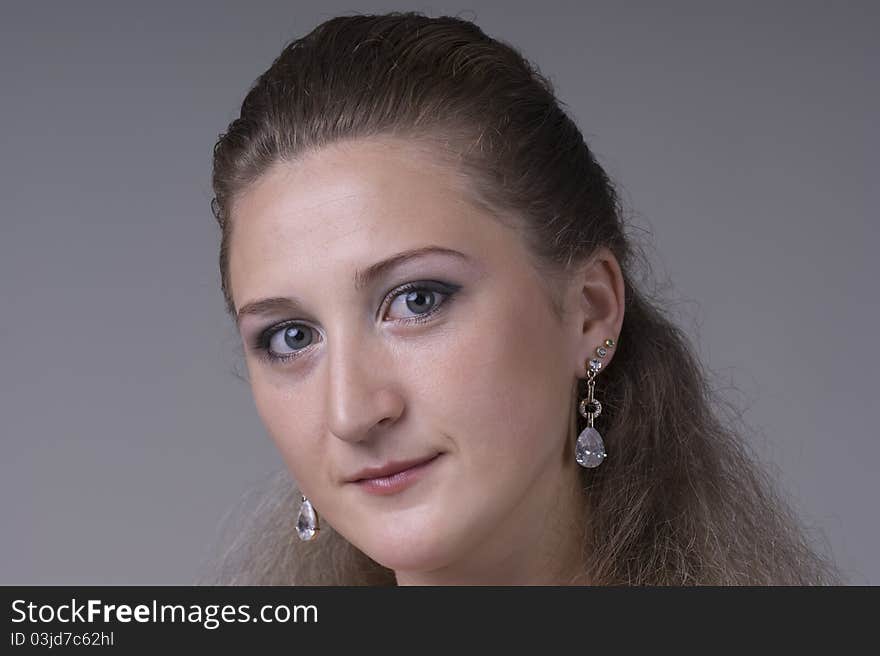 Portrait of a young beautiful woman on a gray background closeup. Portrait of a young beautiful woman on a gray background closeup