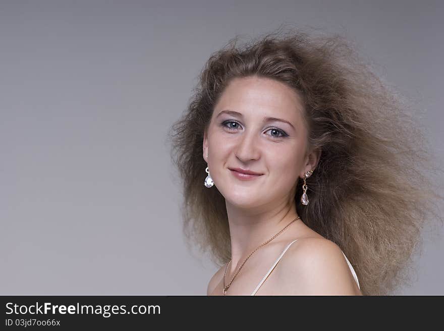 Portrait of a young beautiful woman on a gray background closeup. Portrait of a young beautiful woman on a gray background closeup