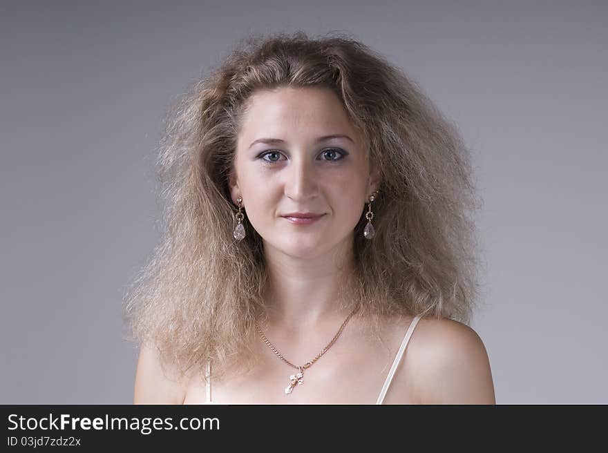 Portrait of a  young beautiful woman on a gray background closeup. Portrait of a  young beautiful woman on a gray background closeup