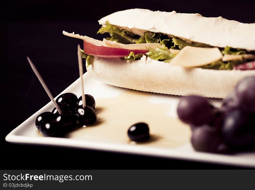 Long baguette sandwich with cheese,  fresh vegetables and olives. Long baguette sandwich with cheese,  fresh vegetables and olives