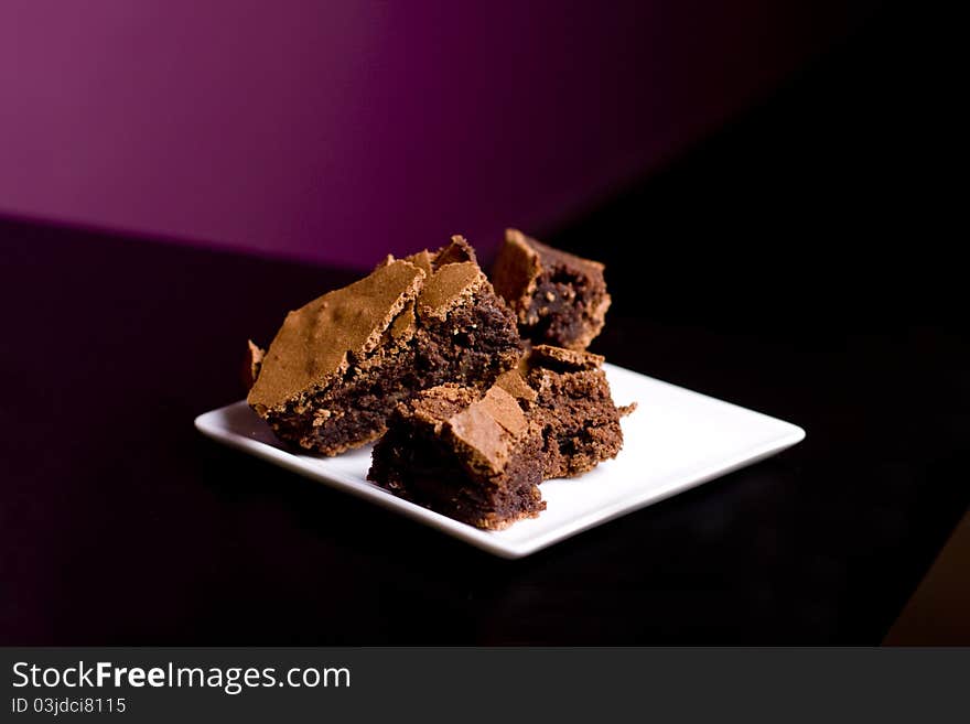 Chocolate Brownies on a White Platter on a restaurant table. Chocolate Brownies on a White Platter on a restaurant table