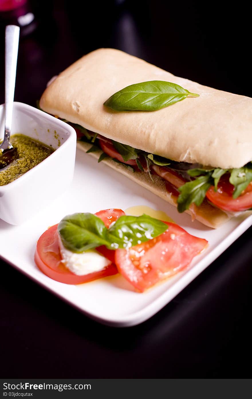 Long baguette sandwich with ham, fresh vegetables and pesto. Long baguette sandwich with ham, fresh vegetables and pesto