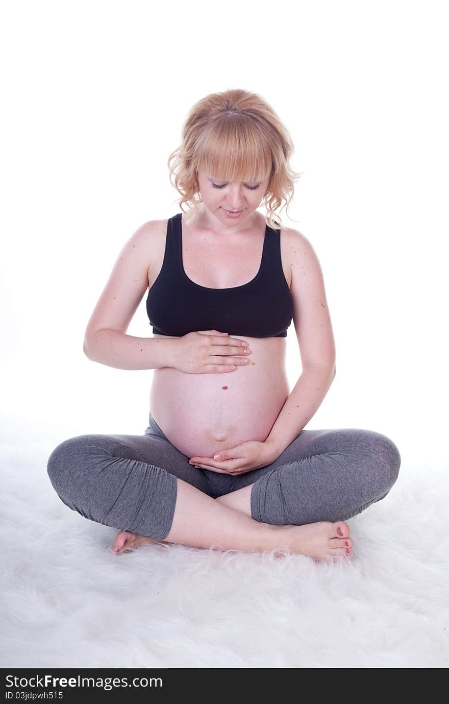 Beautiful pregnant woman doing physical exercises, studio shot