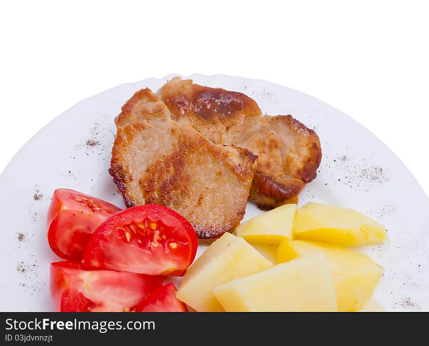 Meat with potato and tomato on white plate, isolated on white background. Meat with potato and tomato on white plate, isolated on white background