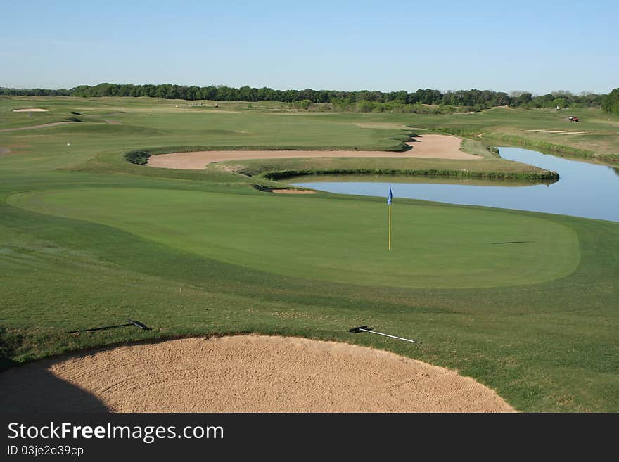 View of a green with approach shot over water hazard and sand trap. View of a green with approach shot over water hazard and sand trap