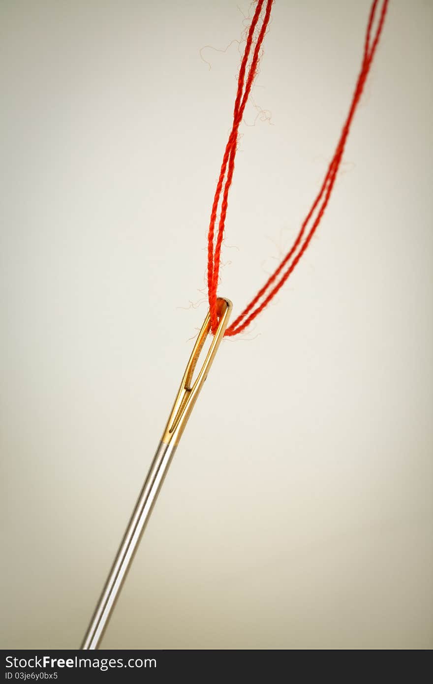 Needle eye with red thread