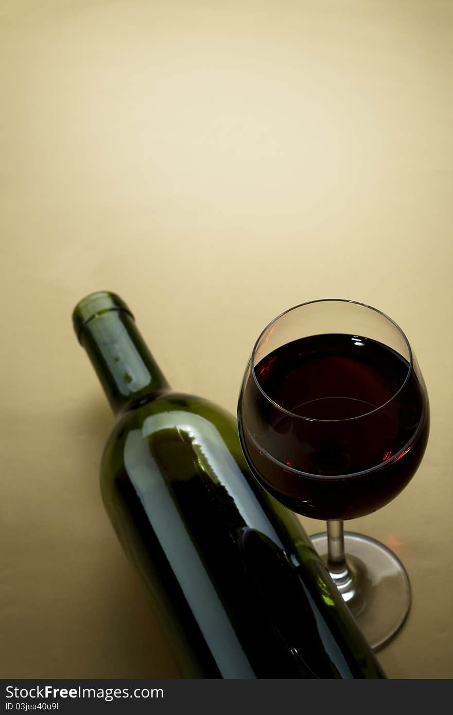 Bottle and glass of wine on a dark background