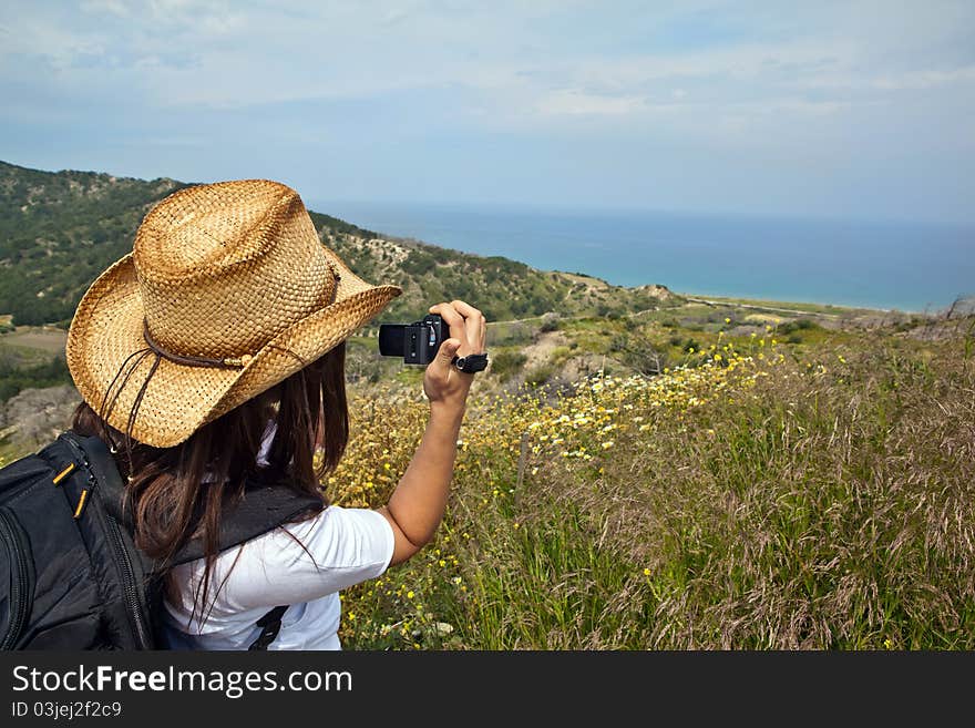 Young woman with backpack taking photo