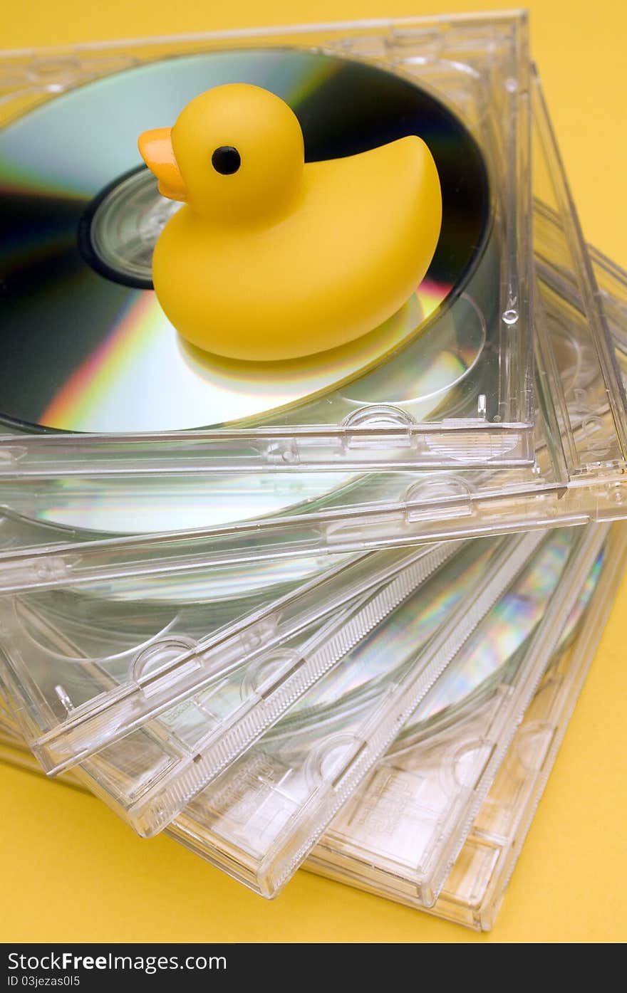 A yellow rubber duck on bunch of cd. A yellow rubber duck on bunch of cd