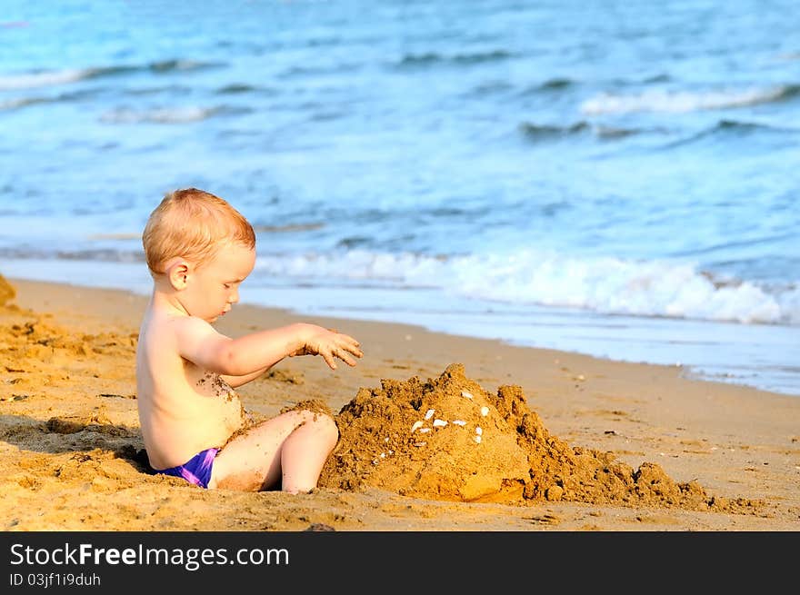 Baby boy playing on beach in sunset. Baby boy playing on beach in sunset