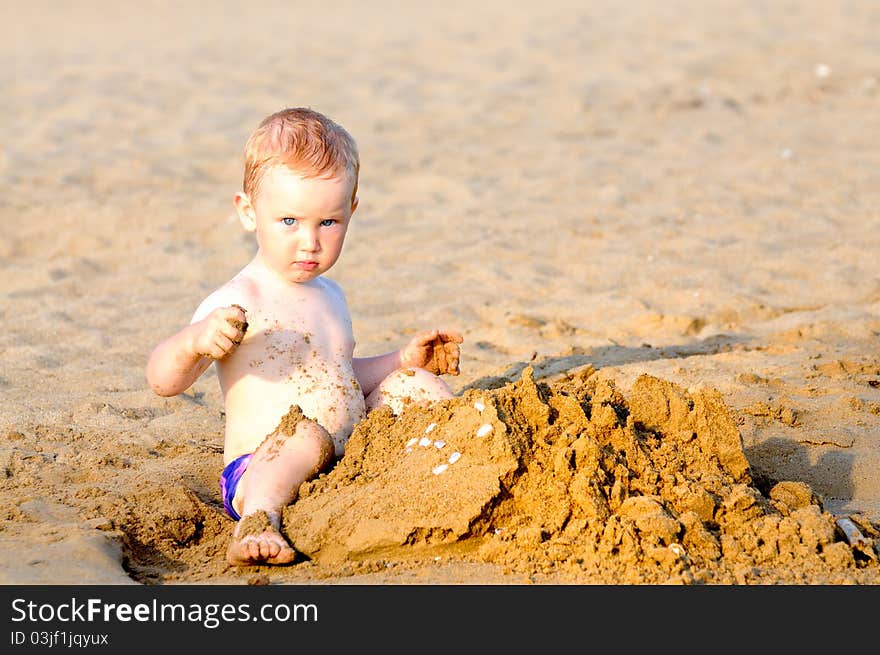 Baby boy playing on beach in sunset. Baby boy playing on beach in sunset