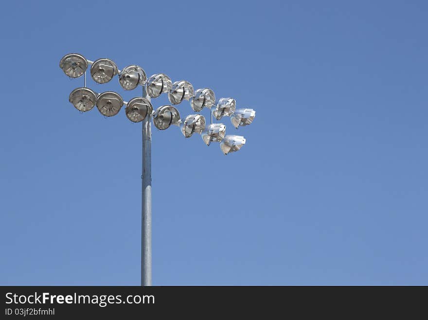 Stadium lights on a blue sky background