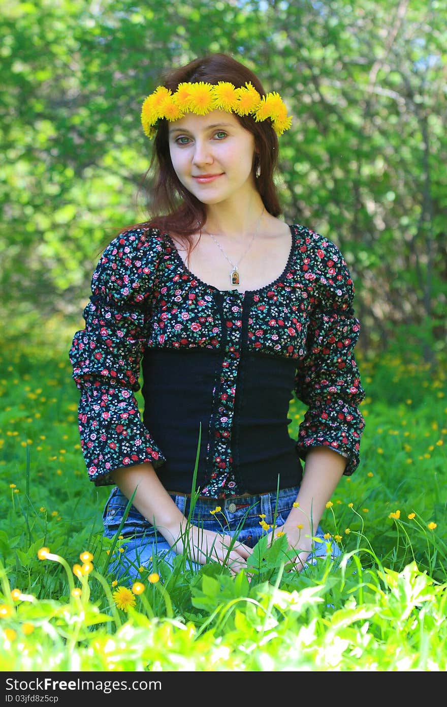 Pretty young white woman sitting in the fled wearing a flower crown. Pretty young white woman sitting in the fled wearing a flower crown