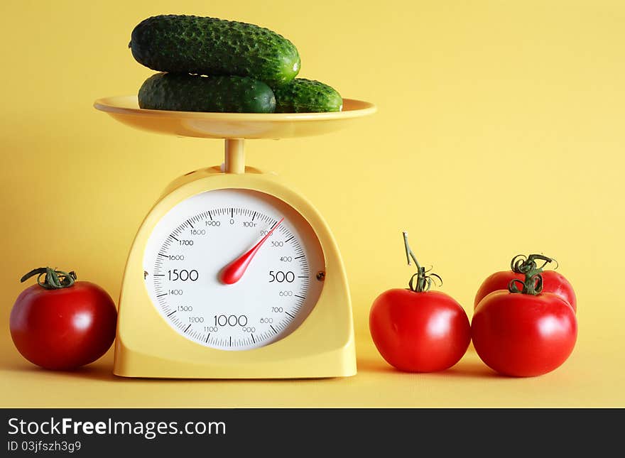 Still life with modern kitchen scale and vegetables on yellow background. Still life with modern kitchen scale and vegetables on yellow background