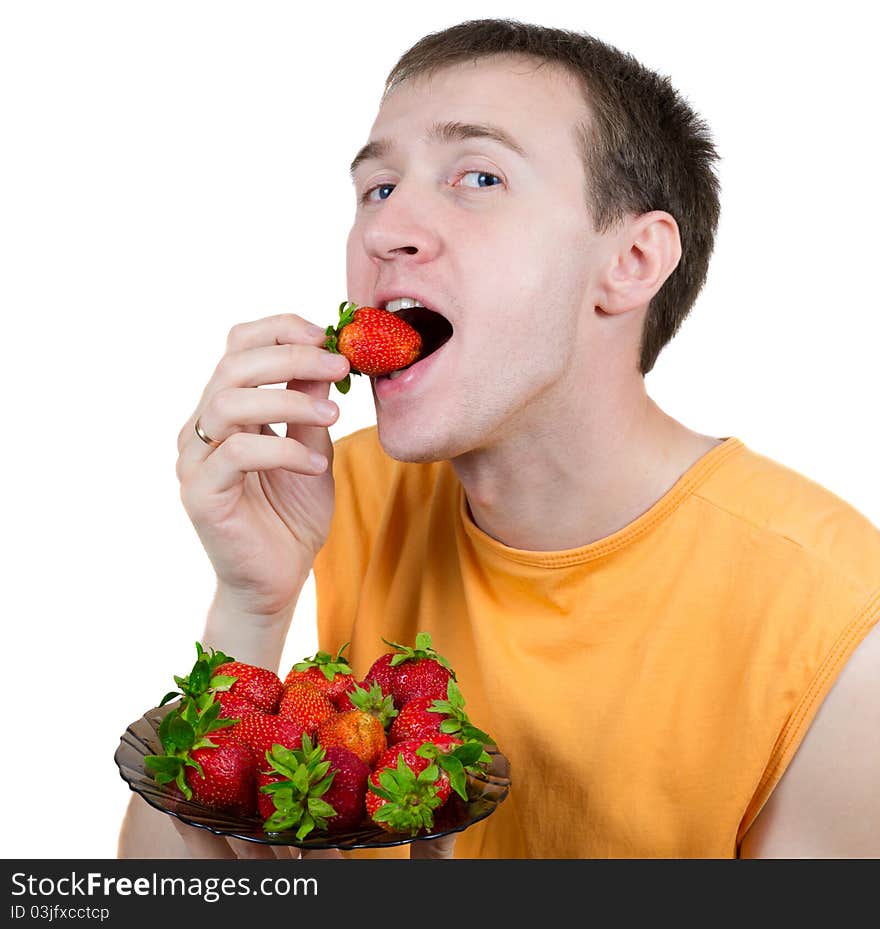 Young the man eats a strawberry isolated