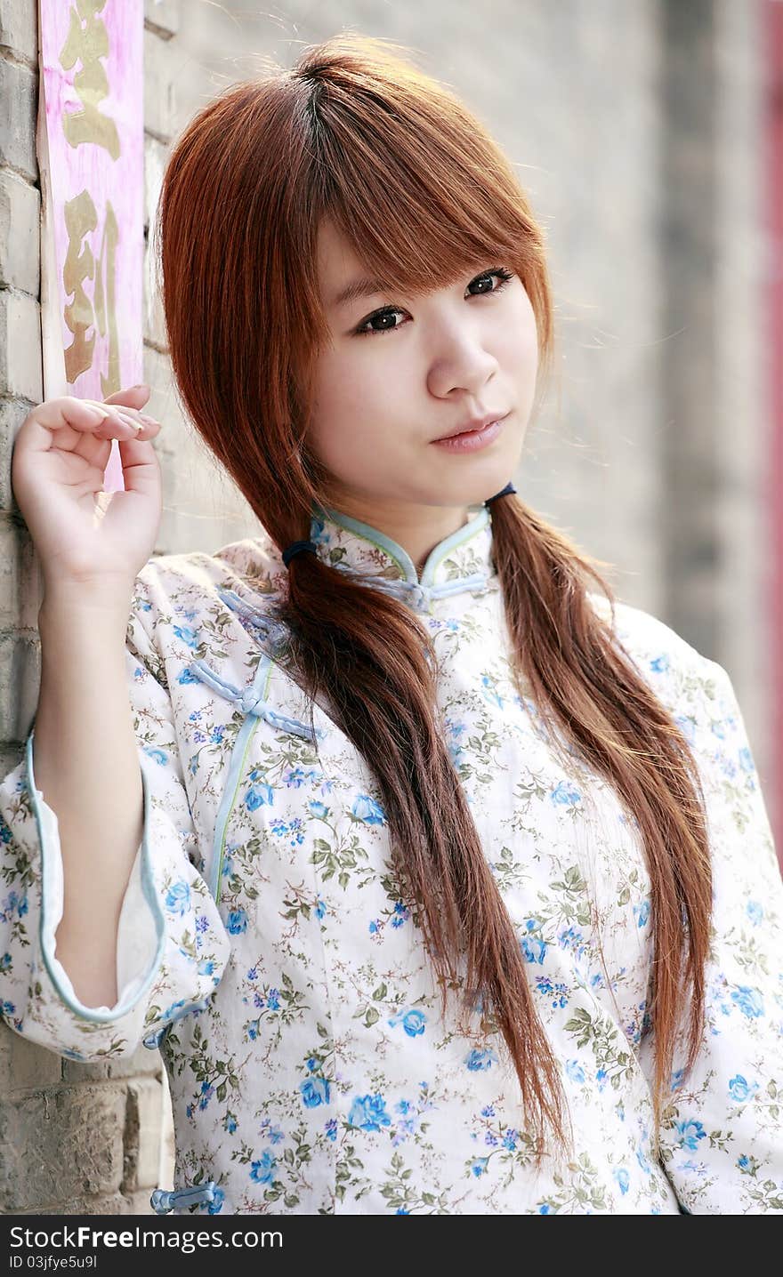 Chinese girl in traditional dress outdoor portrait. Chinese characters on couplet is luck come. Chinese girl in traditional dress outdoor portrait. Chinese characters on couplet is luck come.