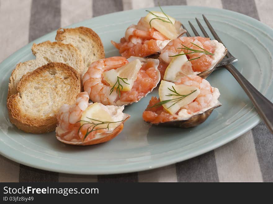 Scallop shells with prawns, king prawns and smoked salmon on a plate. Scallop shells with prawns, king prawns and smoked salmon on a plate