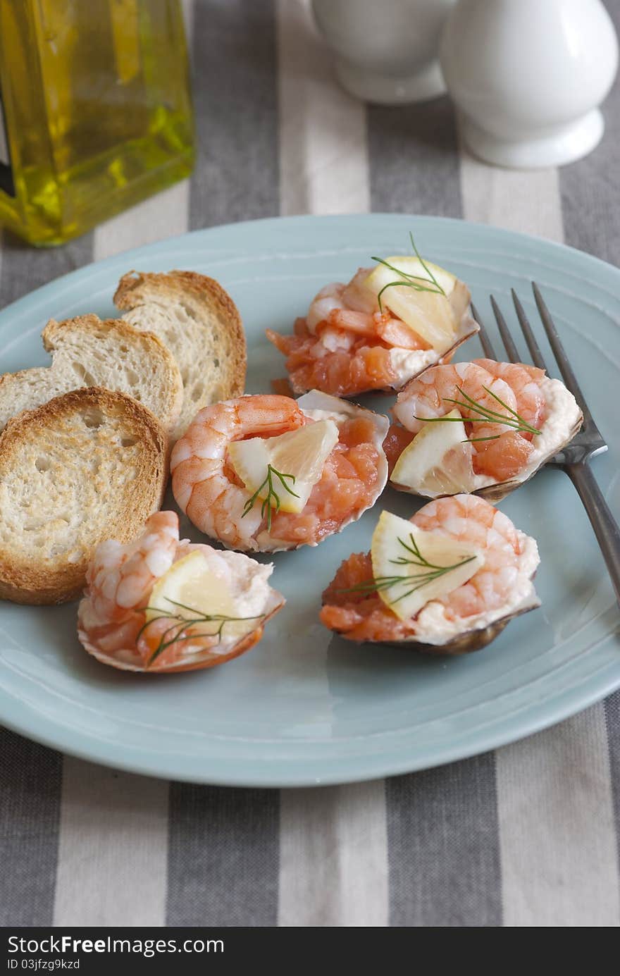 Scallop shells with prawns, king prawns and smoked salmon on a plate. Scallop shells with prawns, king prawns and smoked salmon on a plate