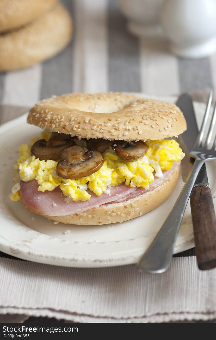 Bagel filled with scrambled egg, mushrooms and bacon. Bagel filled with scrambled egg, mushrooms and bacon