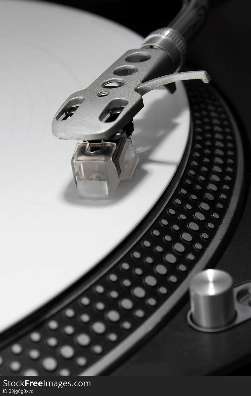 Tonearm with needle playing white vinyl record