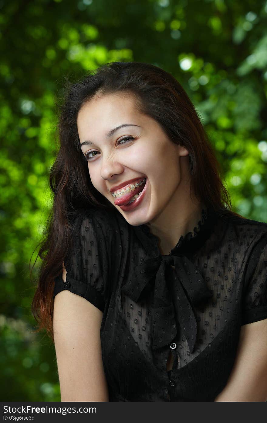 Model girl with braces on a background of trees. Model girl with braces on a background of trees