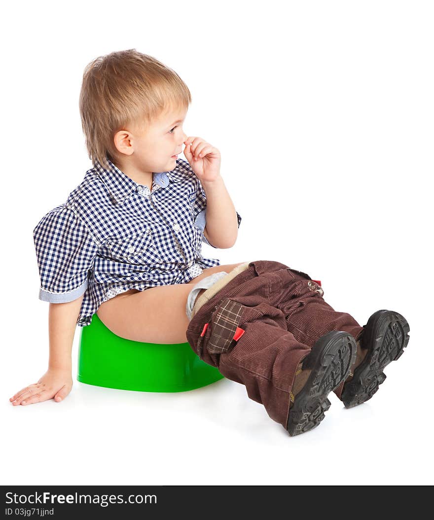 A boy sitting on the pot. Isolated on a white background