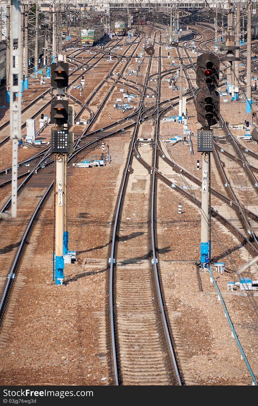 Semaphores against the railway station. electric trains are staying by the platform