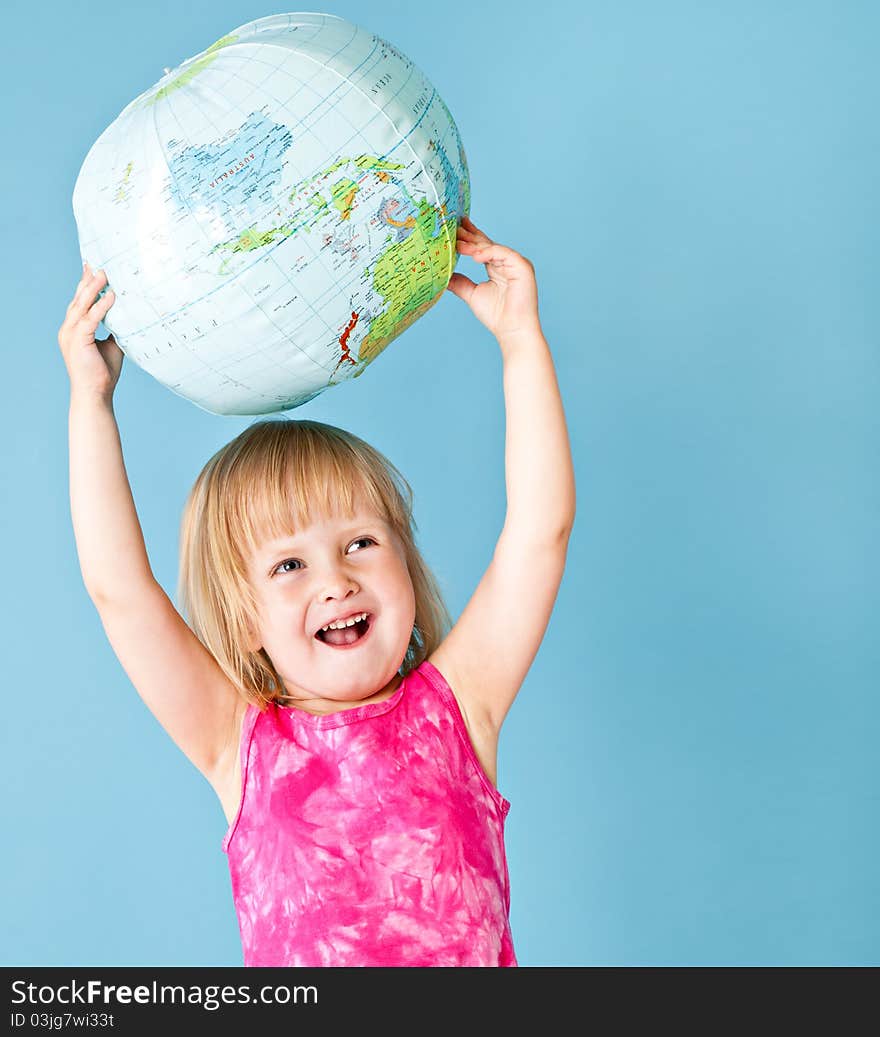 A little girl with a globe on a blue background