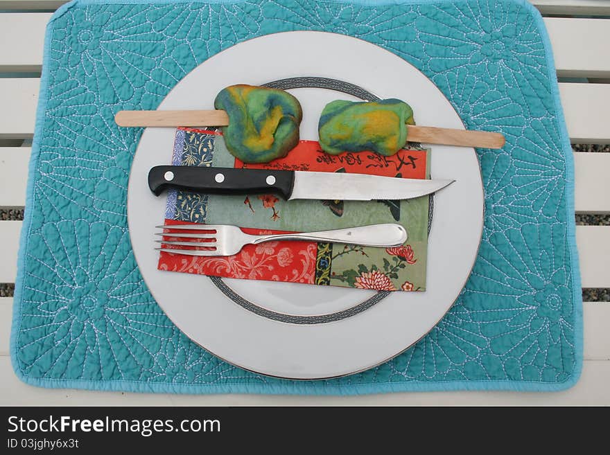 Blue place mat with plate, knife, fork, napkin and cookies. Blue place mat with plate, knife, fork, napkin and cookies.