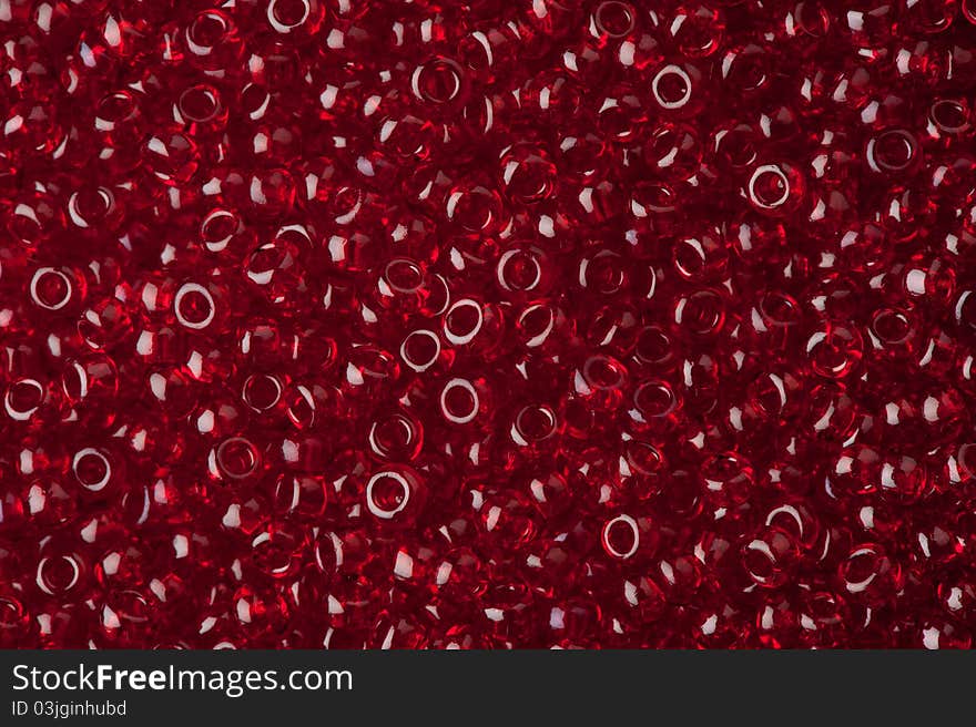 Red polished glass beads background, macro