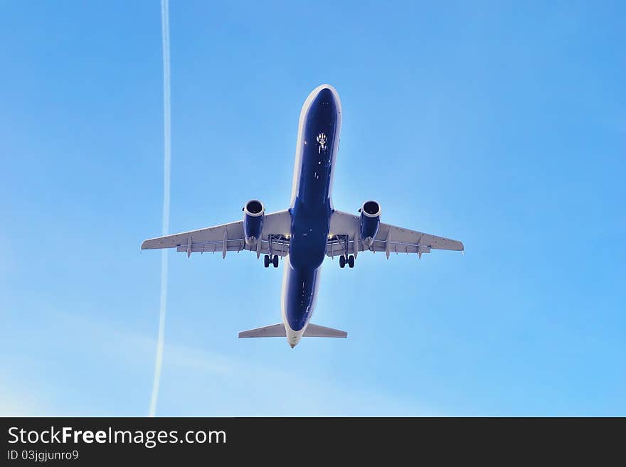 Airbus in blue sky and trace of another airplane.