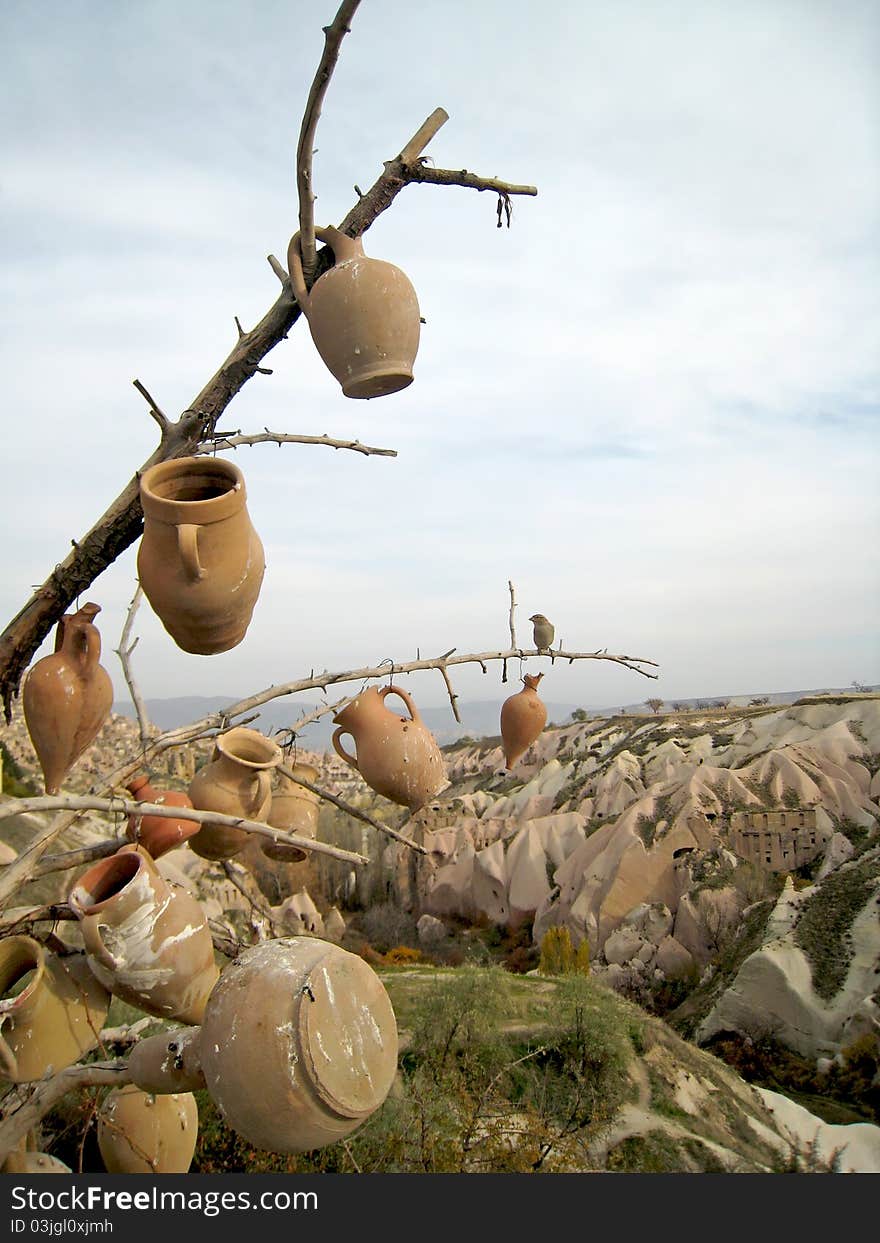 Turkey. Cappadocia. Rocky formations near Goreme (Gereme) and tree with pots