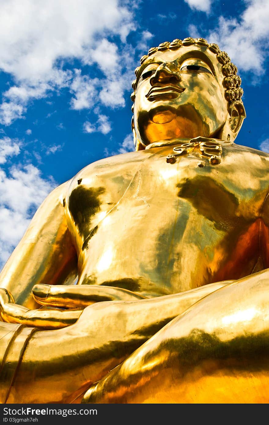 Golden buddha with blue sky and white crown