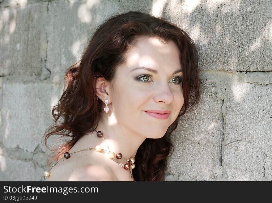 Portrait of beautiful young woman on background a lithoidal wall