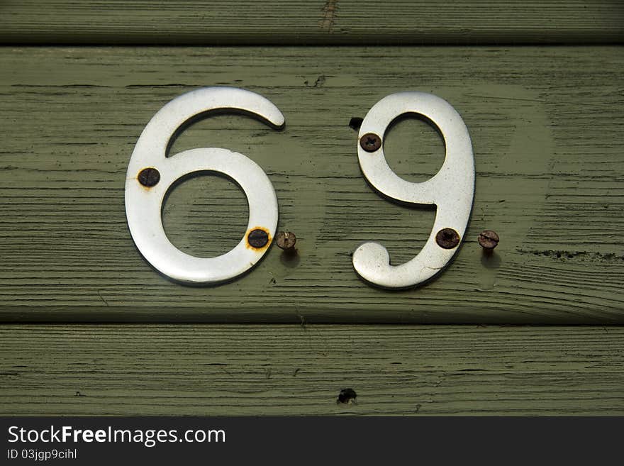 Metal number 69 on green painted front door. Metal number 69 on green painted front door