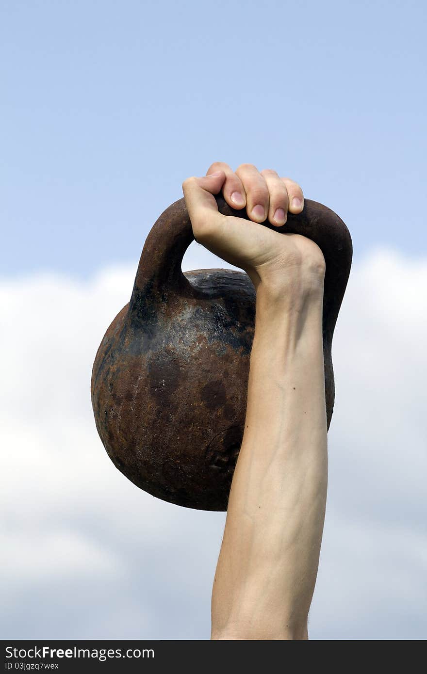 Tool weight hand athlete against the sky. Tool weight hand athlete against the sky