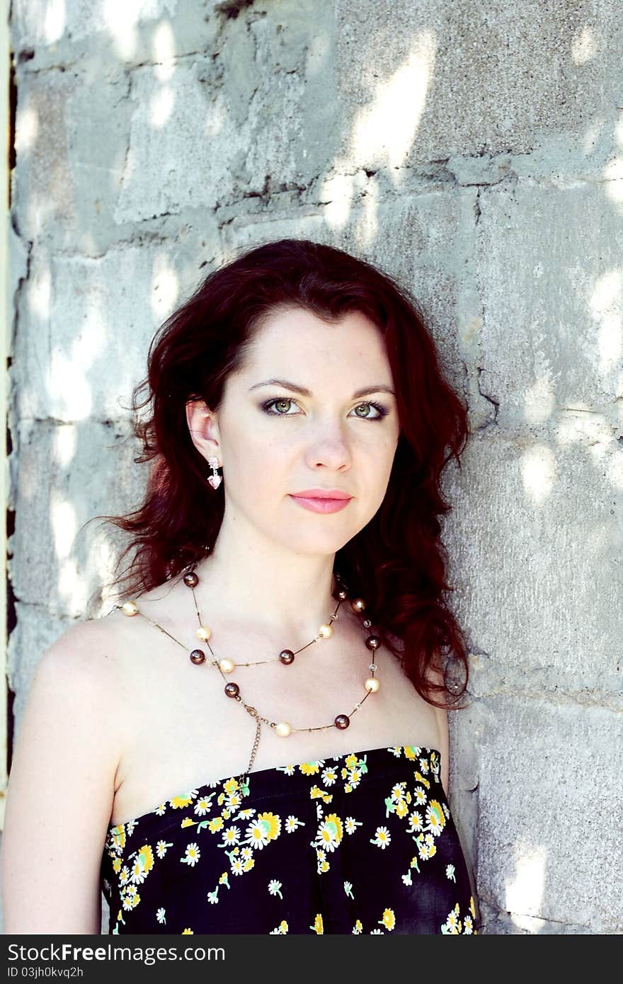 Portrait of beautiful young woman on background stone wall. Cross processed image