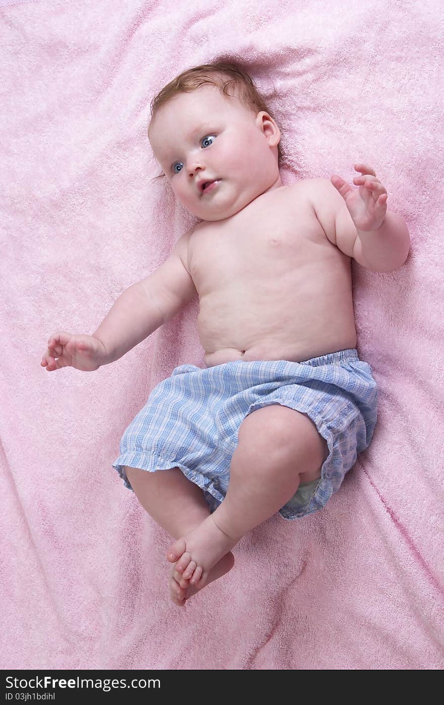 Little baby girl over soft pink towel background. Little baby girl over soft pink towel background