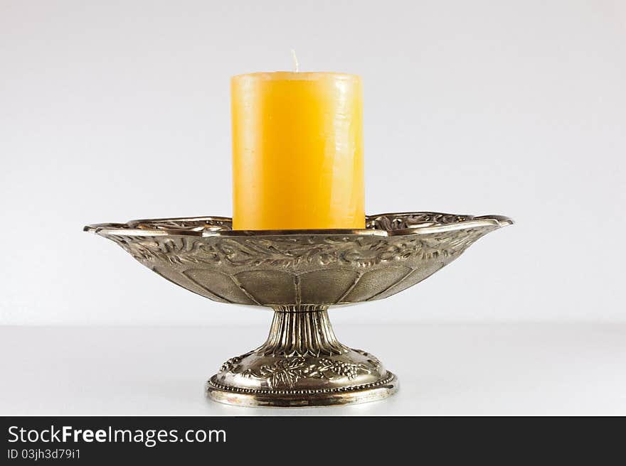 Yellow candle in silver bowl. Yellow candle in silver bowl