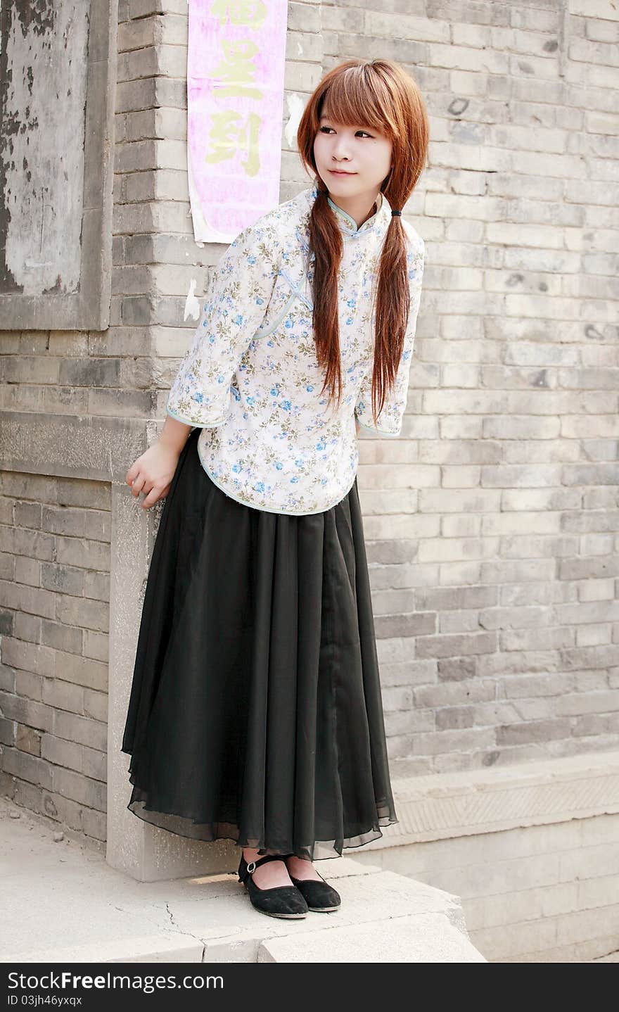 Chinese girl in traditional dress outdoor . Chinese characters on couplet is luck come. Chinese girl in traditional dress outdoor . Chinese characters on couplet is luck come.